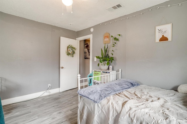 bedroom with hardwood / wood-style flooring and a textured ceiling