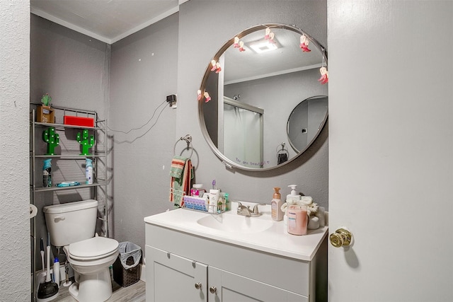 bathroom featuring crown molding, a shower with door, vanity, wood-type flooring, and toilet