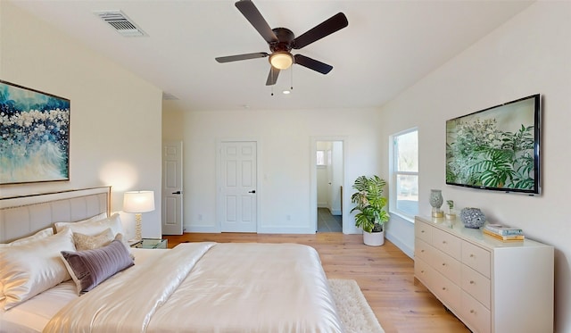 bedroom featuring connected bathroom, light hardwood / wood-style floors, and ceiling fan