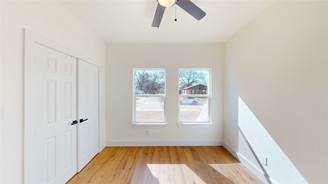 unfurnished bedroom with light hardwood / wood-style flooring, a closet, and ceiling fan