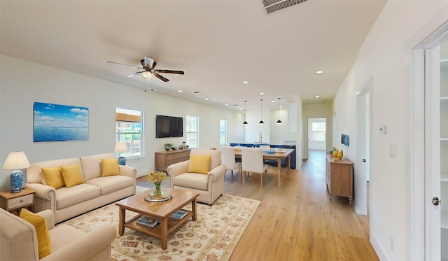 living room featuring ceiling fan and light hardwood / wood-style flooring