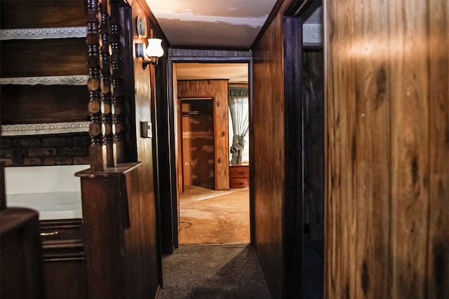 hall with dark carpet and wood walls