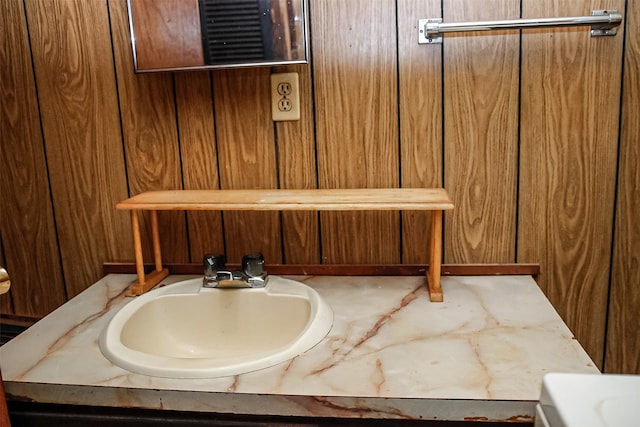 bathroom featuring vanity and wood walls