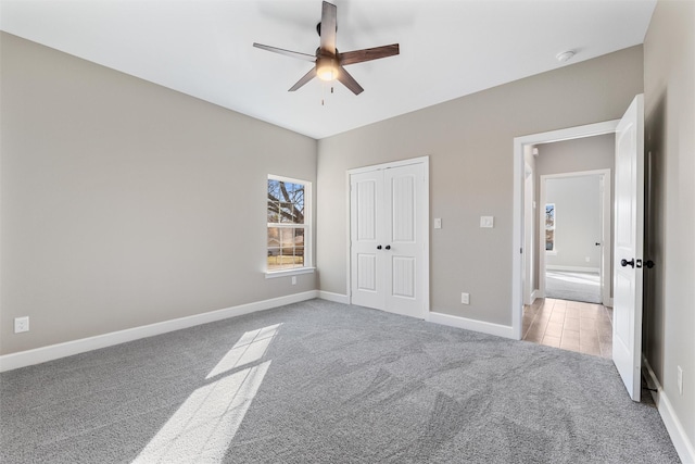 unfurnished bedroom featuring a closet, ceiling fan, and carpet