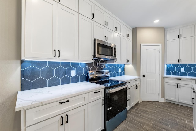 kitchen featuring white cabinetry, stainless steel appliances, and light stone counters