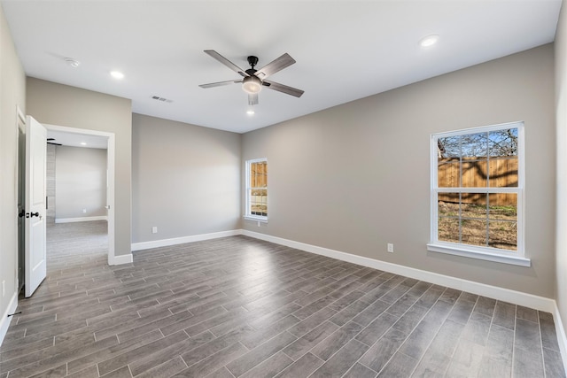 spare room with ceiling fan, plenty of natural light, and hardwood / wood-style floors