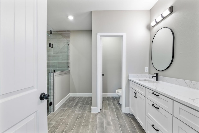 bathroom featuring vanity, walk in shower, and toilet