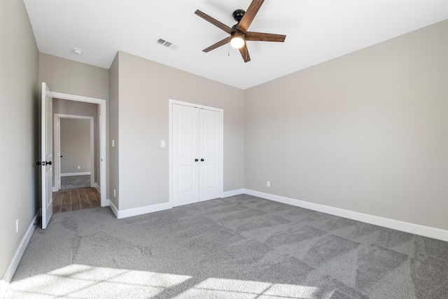 unfurnished bedroom featuring carpet, ceiling fan, and a closet