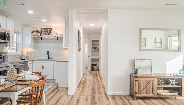 hallway featuring sink and light wood-type flooring