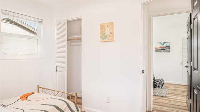 bedroom with light hardwood / wood-style flooring and a closet