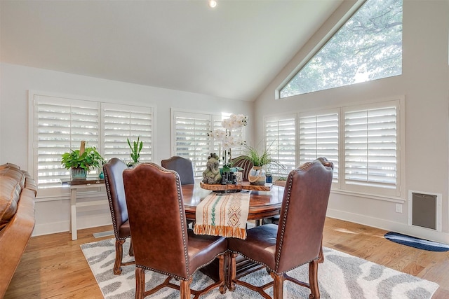 dining room with lofted ceiling and light hardwood / wood-style flooring