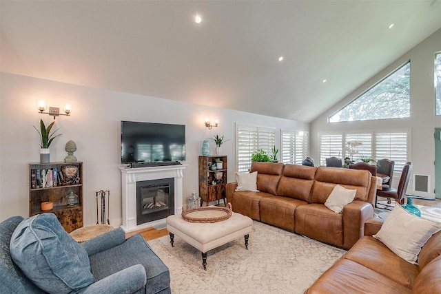 living room featuring high vaulted ceiling and light wood-type flooring