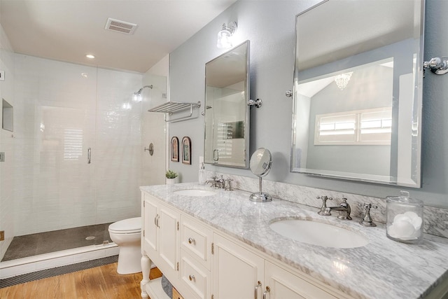 bathroom featuring wood-type flooring, lofted ceiling, vanity, an enclosed shower, and toilet