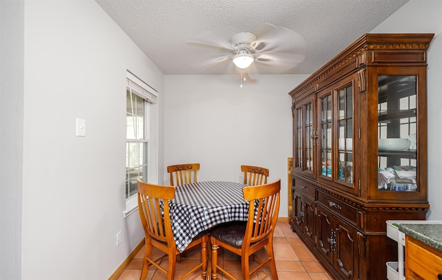 3029 Meadow Creek Ct, Grand Prairie, TX 75052 - dining room with a ceiling fan, a textured ceiling, light tile patterned floors, and baseboards