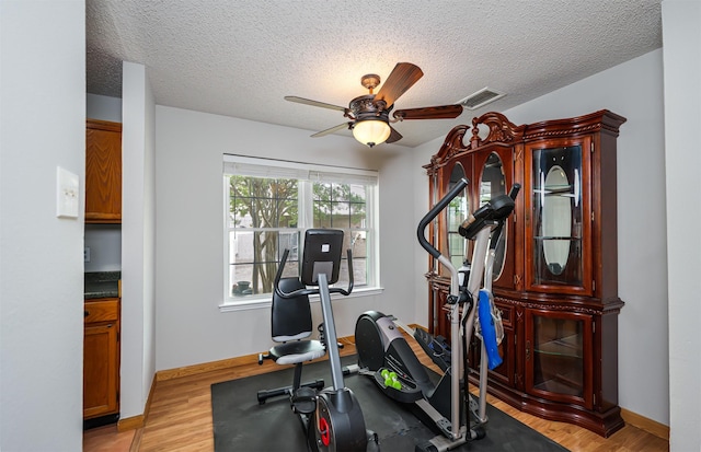 3029 Meadow Creek Ct, Grand Prairie, TX 75052 - workout room with a ceiling fan, a textured ceiling, light wood finished floors, and baseboards
