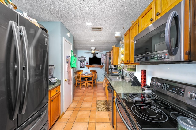 kitchen featuring sink, a textured ceiling, light tile patterned floors, ceiling fan, and black appliances