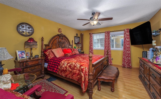 bedroom featuring ceiling fan, light hardwood / wood-style flooring, and a textured ceiling