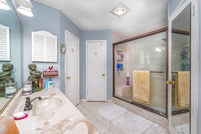 bathroom with vanity, tile patterned floors, a textured ceiling, and walk in shower