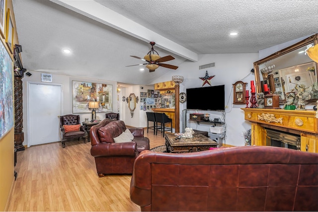 living room with ceiling fan, light hardwood / wood-style floors, a textured ceiling, and vaulted ceiling with beams