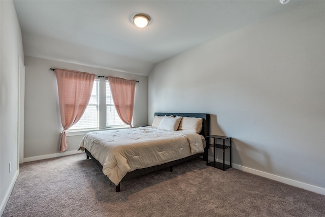 bedroom with vaulted ceiling and dark colored carpet