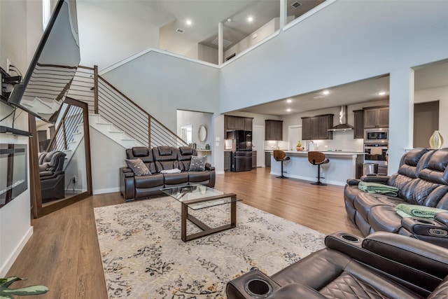 living room featuring light hardwood / wood-style floors and a high ceiling