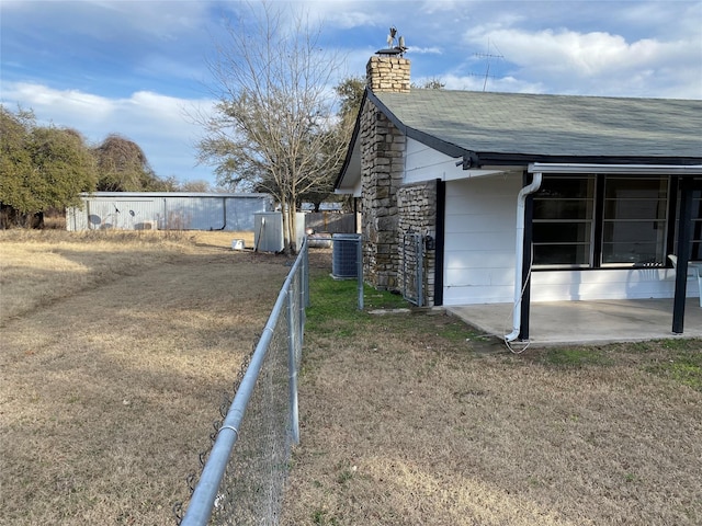 view of property exterior featuring central AC, a yard, and a patio