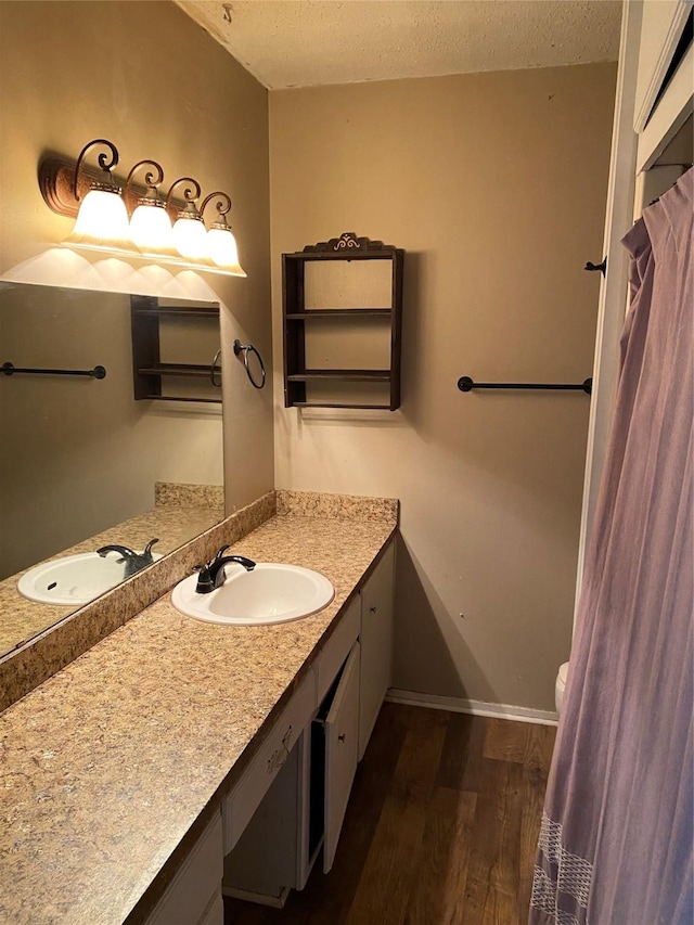 bathroom with vanity, toilet, hardwood / wood-style floors, and a textured ceiling