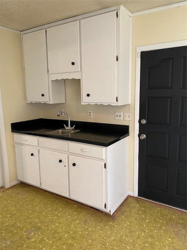 kitchen featuring sink, a textured ceiling, and white cabinets