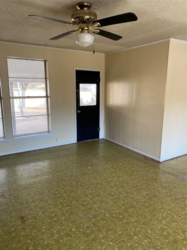 foyer entrance with ceiling fan and a textured ceiling