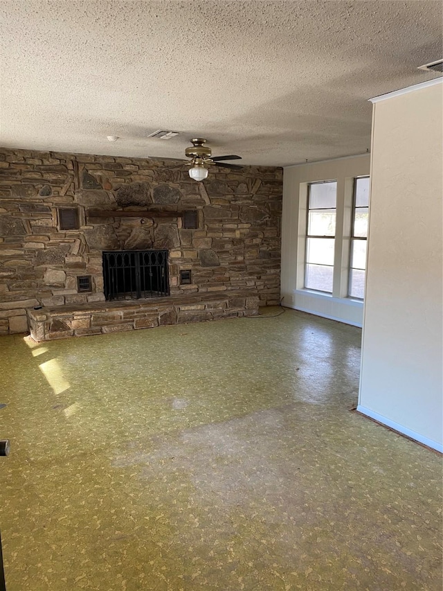 unfurnished living room with ceiling fan, a textured ceiling, and a fireplace