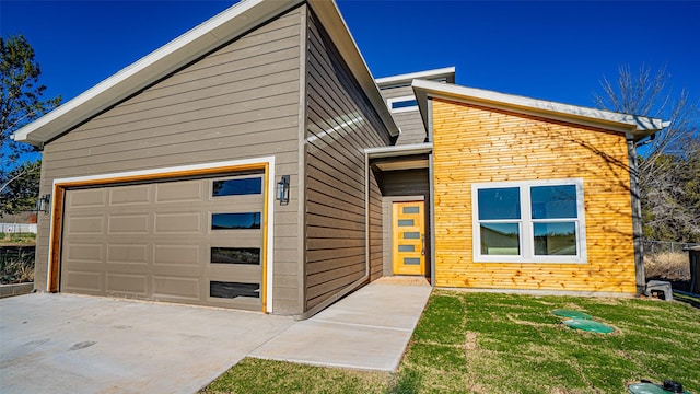 contemporary house featuring a garage and a front yard