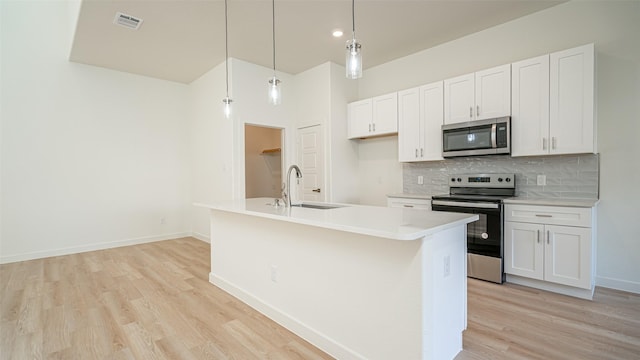 kitchen with pendant lighting, an island with sink, white cabinetry, sink, and stainless steel appliances