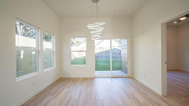 interior space featuring a notable chandelier, light hardwood / wood-style floors, and a healthy amount of sunlight