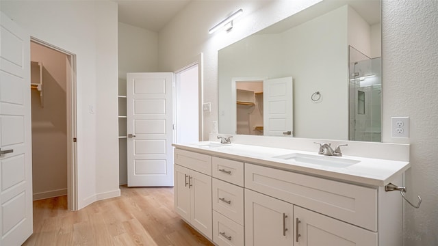 bathroom with an enclosed shower, vanity, and hardwood / wood-style flooring