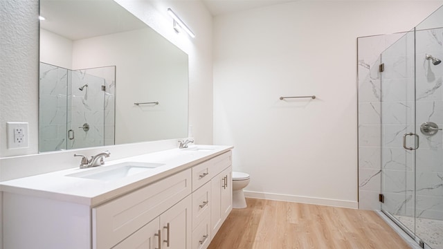 bathroom featuring hardwood / wood-style flooring, vanity, an enclosed shower, and toilet