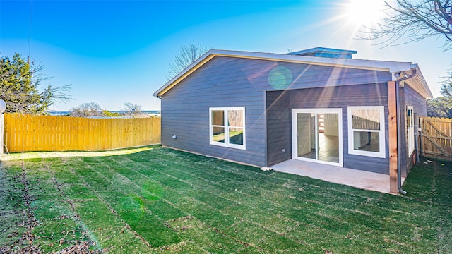 back of property featuring a lawn and a patio