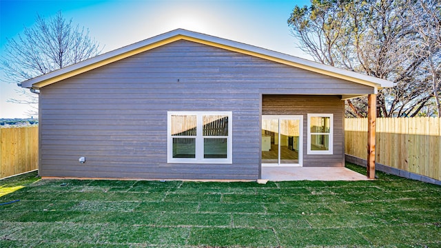 rear view of property with a yard and a patio