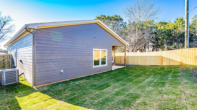 back of property featuring a yard and central air condition unit