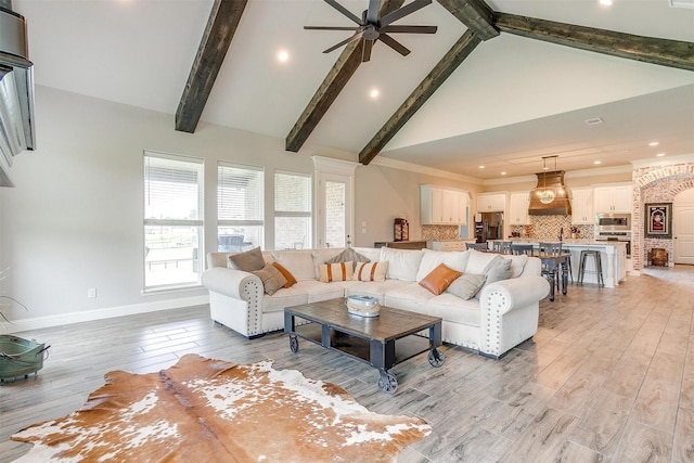 living room with crown molding, ceiling fan, high vaulted ceiling, beamed ceiling, and light wood-type flooring