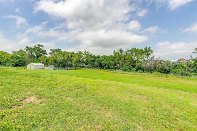 view of yard featuring a rural view and a storage unit