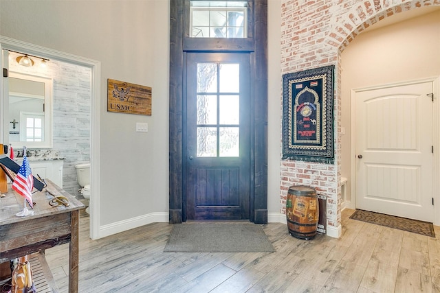 entryway with a towering ceiling and light hardwood / wood-style flooring