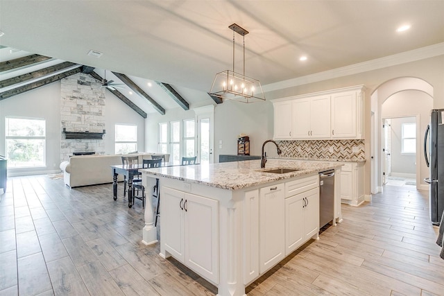 kitchen featuring ceiling fan, a kitchen island with sink, white cabinetry, light stone countertops, and decorative light fixtures