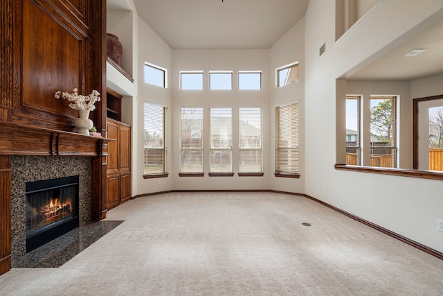 living room featuring a high ceiling, light colored carpet, and a high end fireplace