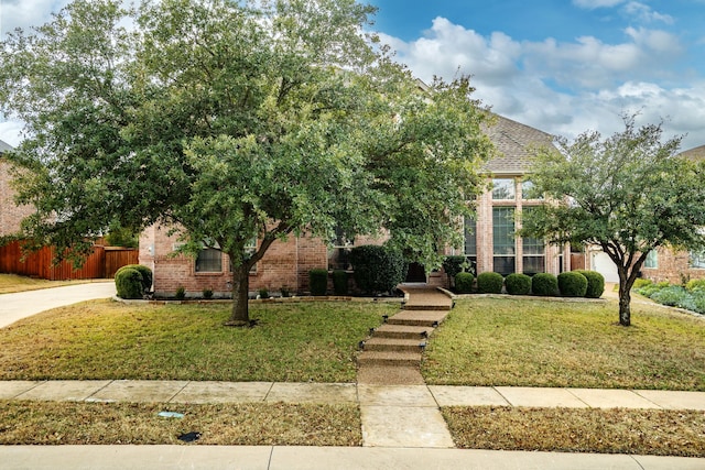 view of property hidden behind natural elements featuring a front yard