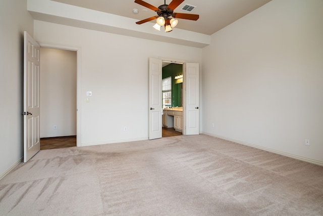 unfurnished bedroom featuring connected bathroom, carpet, a ceiling fan, baseboards, and visible vents