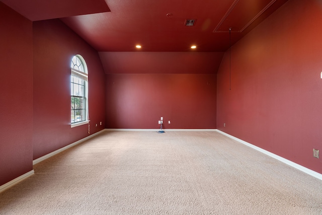 carpeted spare room with vaulted ceiling