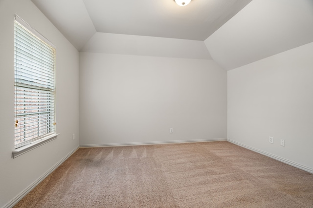 bonus room with vaulted ceiling and light carpet