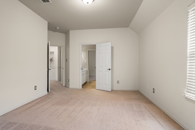 unfurnished bedroom with light carpet and vaulted ceiling