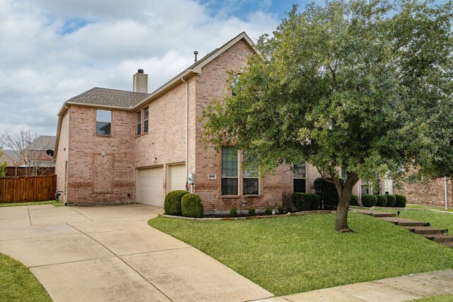 view of front of property with fence, an attached garage, brick siding, a front yard, and driveway