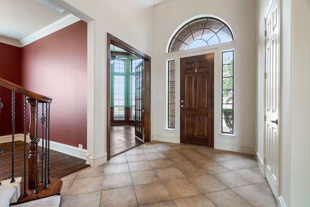 entrance foyer with crown molding and light tile patterned flooring